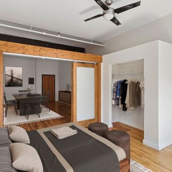 A bedroom with a bed, a dining table, and a wardrobe.